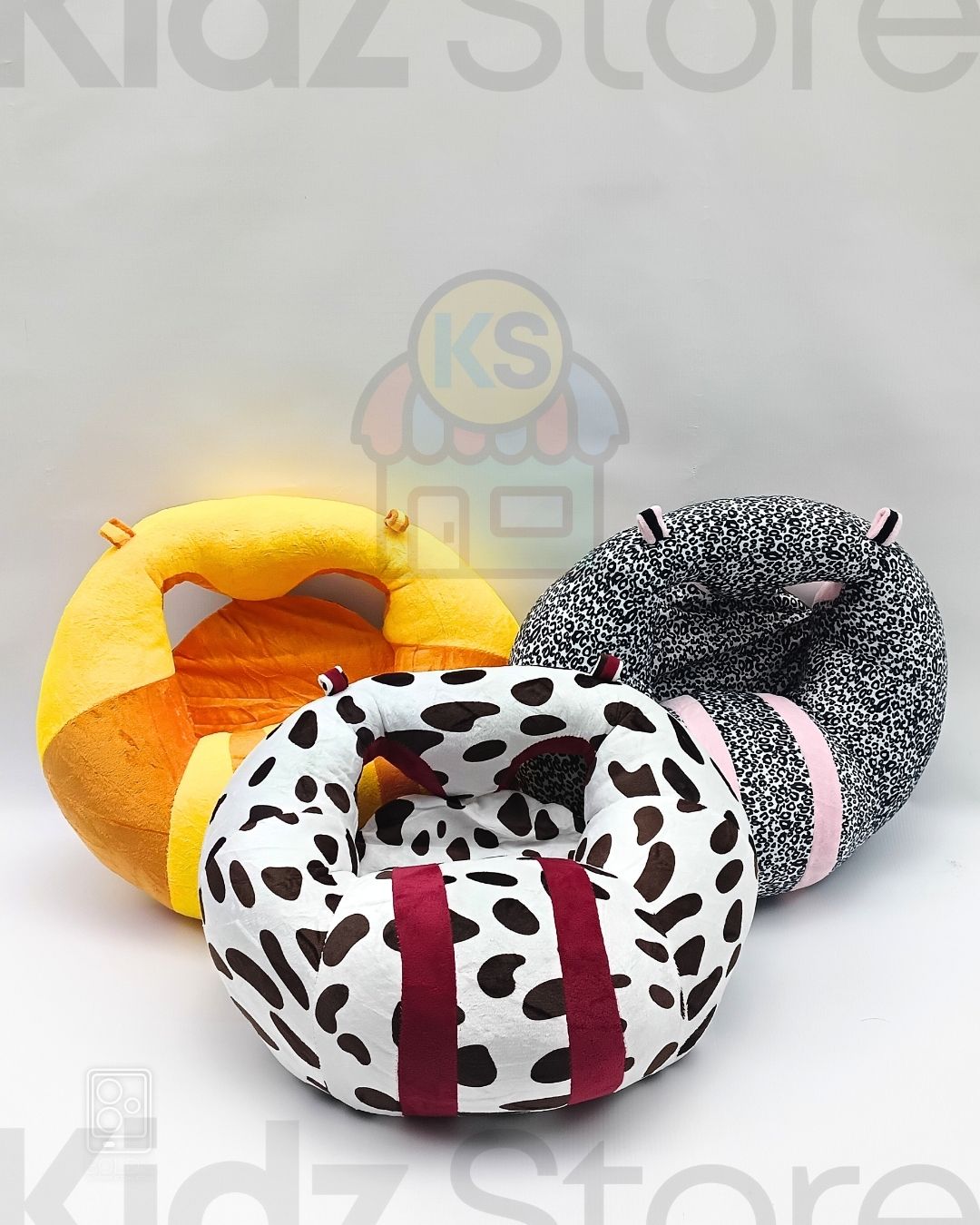 Four colorful donut-shaped cushions with animal patterns on a light gray background, featuring 'KIDZ Store' branding.