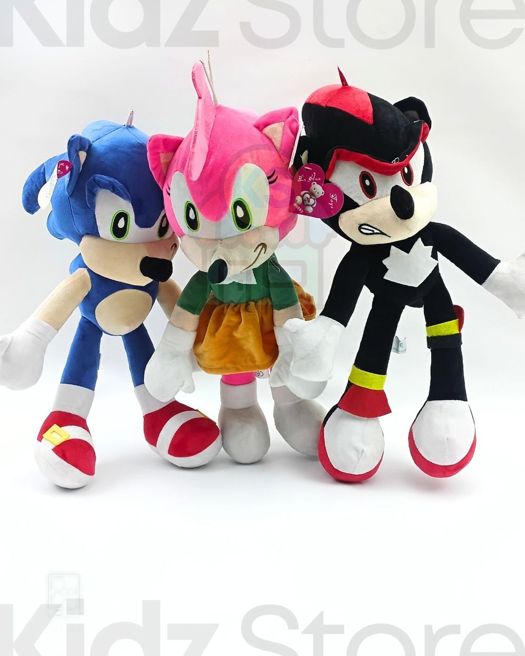 Three colorful plush toys on a white background with 'Kidz Store' branding.