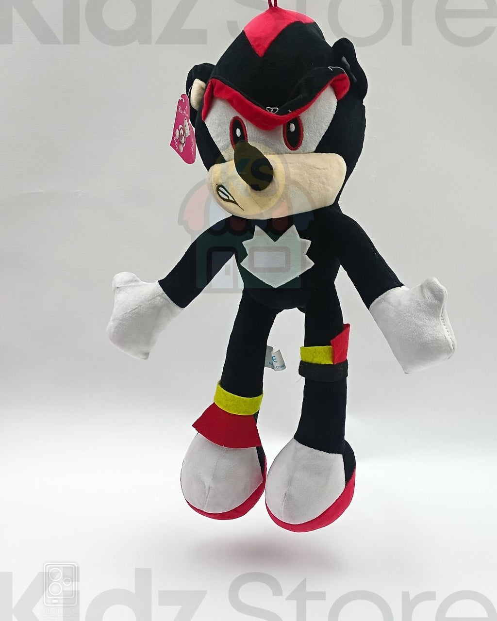 Plush toy of a character with black, red, and white colors on a light gray background.