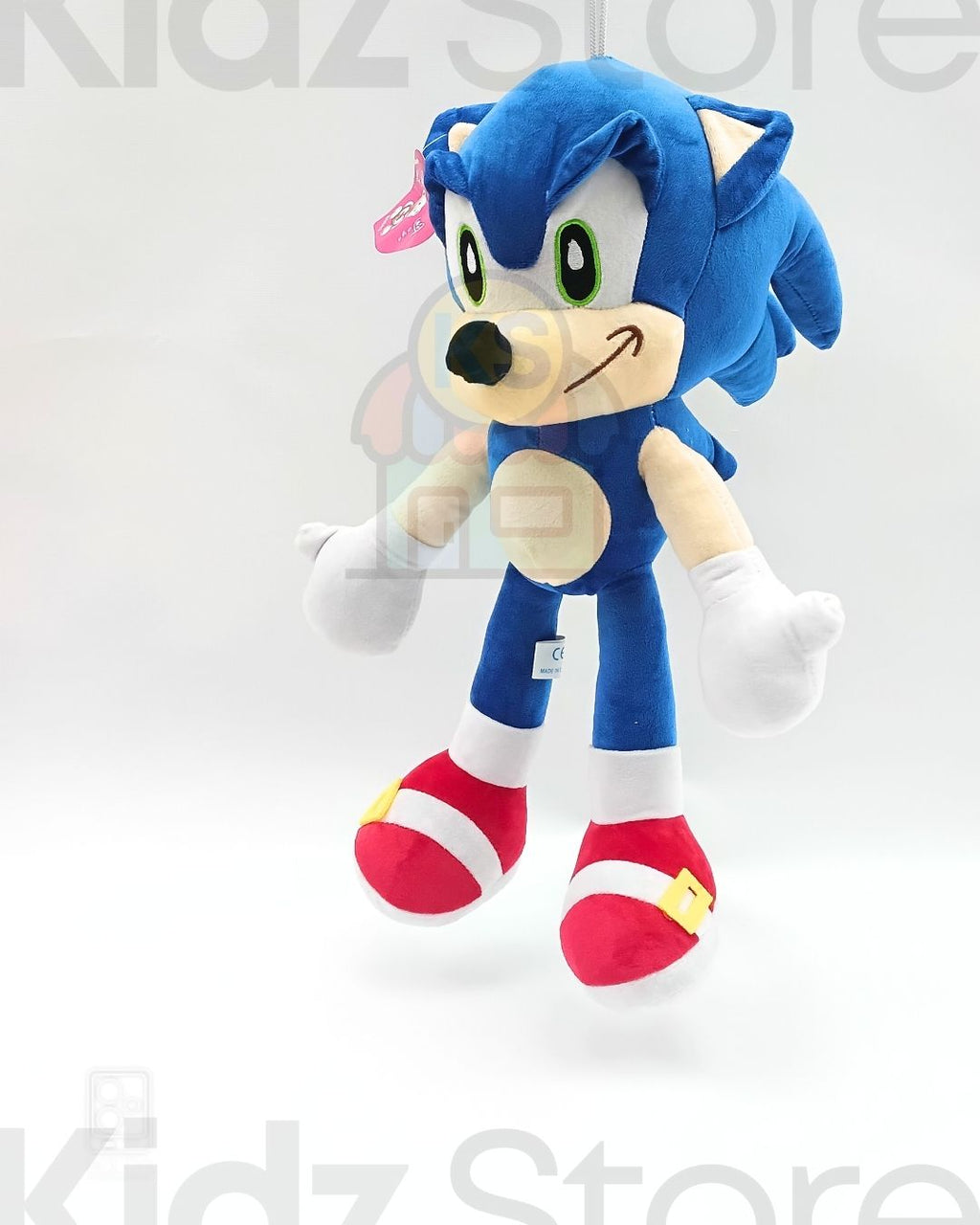 Blue plush toy with red shoes on a white background