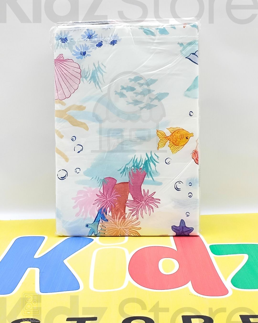 Colorful underwater-themed product packaging on a 'Kidz Store' background