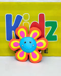 Colorful flower-shaped toy with a blue center against a yellow background with 'Kidz' text