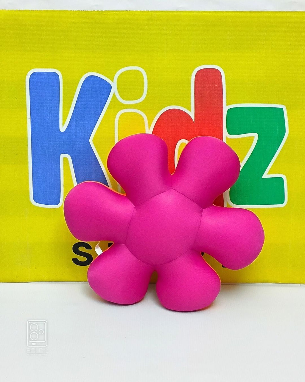 Pink stress ball against a yellow background with colorful letters spelling 'Kidz'.